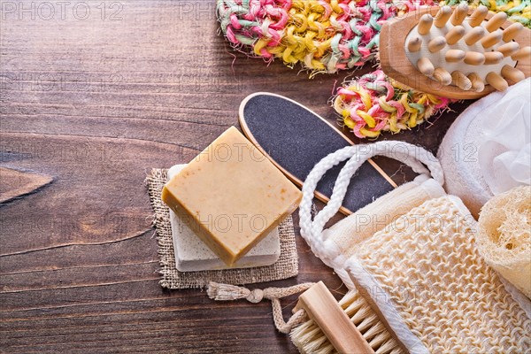Large set of bathroom accessories bar soap wisp massager loofah nail brush on vintage wooden board with small copyspace