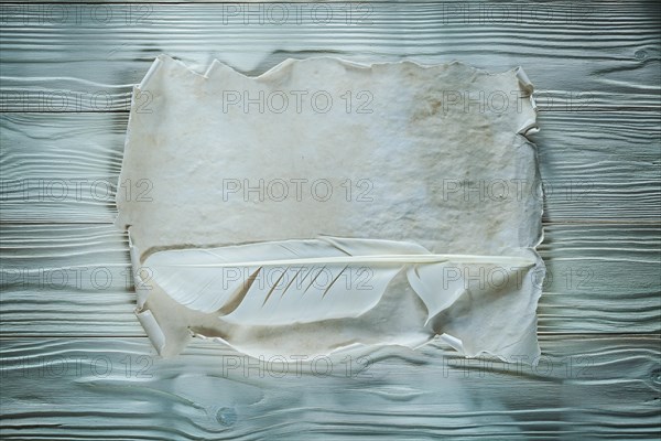 Quill vintage crumpled sheet of paper on wooden board