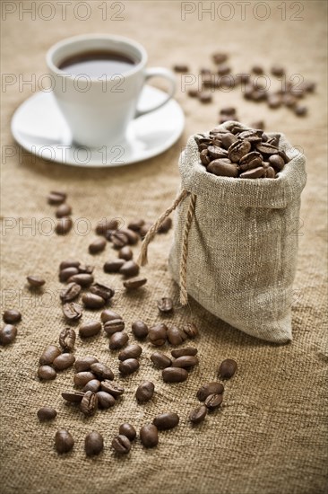 Coffee beans and a cup of coffee on a bag