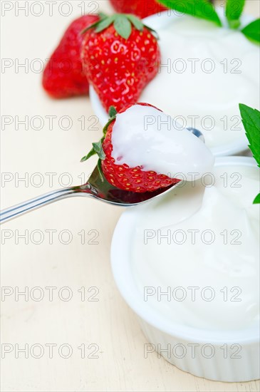 Organic Greek yogurt and strawberry over white rustic wood table