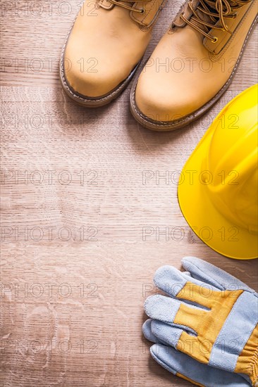 Organised copyspace working boots helmet gloves On Wooden Board