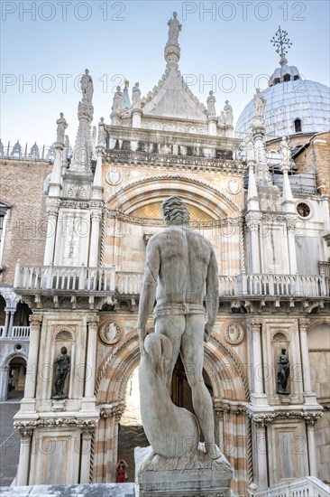 Figure on the giant staircase in the courtyard of the Doge's Palace with St Mark's Basilica