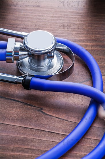 Blue medical stethoscope on vintage wooden board