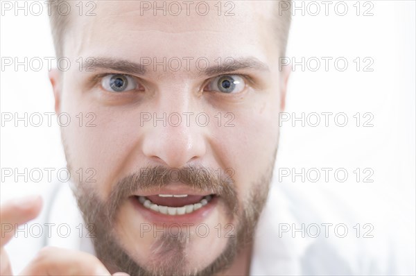 Stylish man with a crazy look is looking at the camera. The concept of suppression