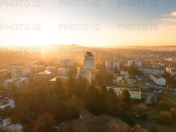 Water tower overlooking the cityscape during a peaceful sunrise