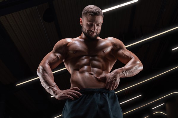 Image of a muscular guy with a naked torso and abs. Gym. Fitness concept