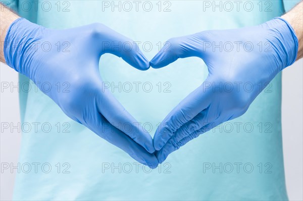 The doctor folded his hands in the shape of a heart. Medical concept.