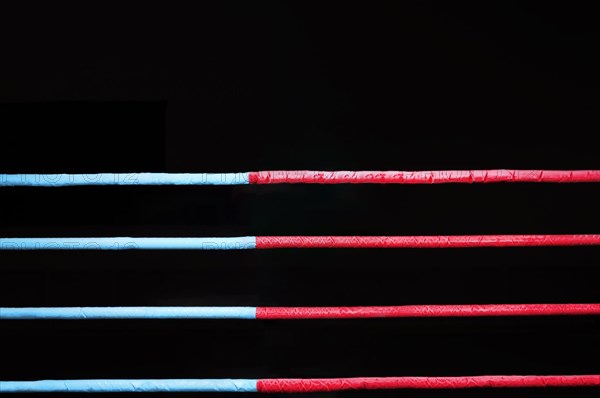 Boxing ring ropes on a black background. The concept of sports