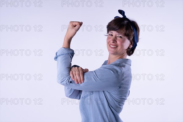 Short-haired girl showing strong arm muscle isolated. Concept WomenÂ´s day. Copy space. Portrait isolated on white background