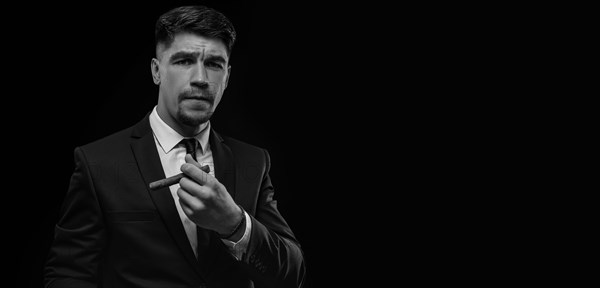 Portrait of a stylish man in a suit with a cigar. Business concept.