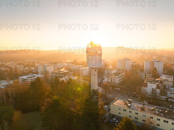 Aerial view morning mood with the sunlight illuminating a water tower and the city