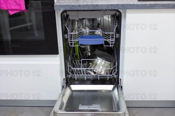 White modern dishwasher in the interior of a white kitchen