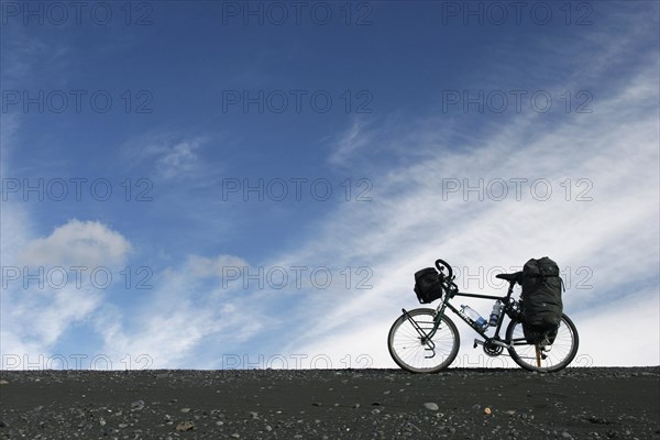Heavily laden touring bicycle against blue sky