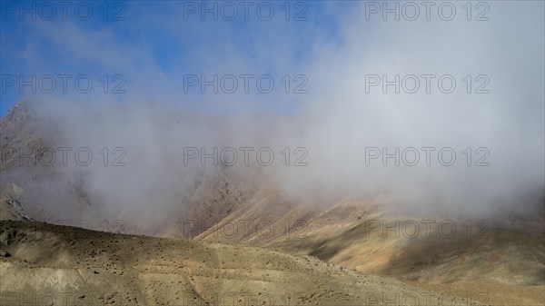 Low hanging clouds in the mountain landscape at the Tizi-n-Tichka pass road, High Atlas, Morocco,