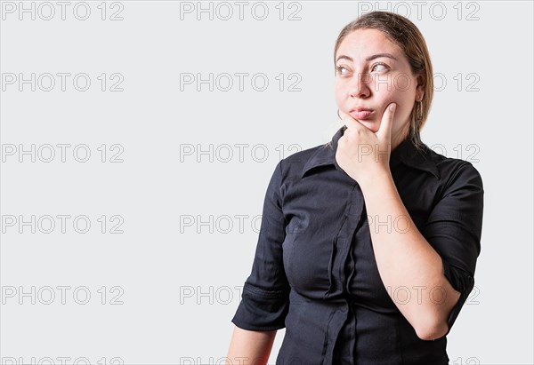 Young woman thinking with hand on chin isolated. Thoughtful beautiful girl with hand on chin