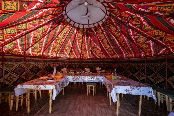 Set table and chairs in a colourful yurt, yurt with traditional patterns, Naryn region, Kyrgyzstan,