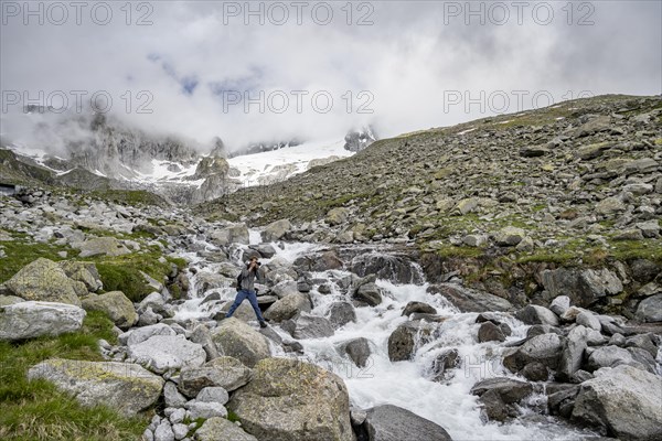 Mountaineers photographed, at a mountain stream, Furtschaglbach, behind rocky mountains with