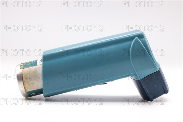 Blue asthma inhaler with blank label isolated on white background. Pharmaceutical product is used