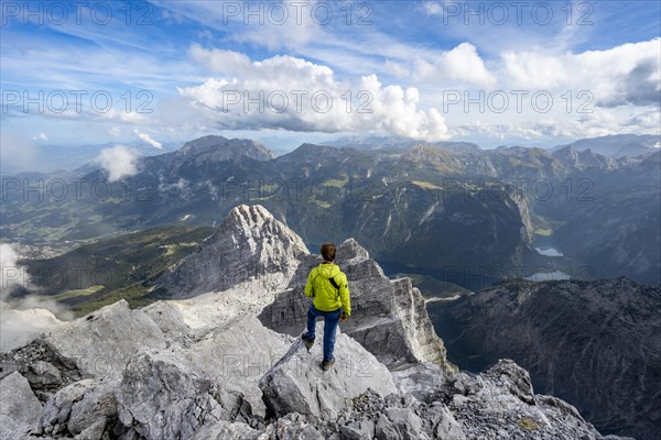 Mountaineer on the rocky summit of the Watzmann Mittelspitze, Watzmann crossing, view of mountain