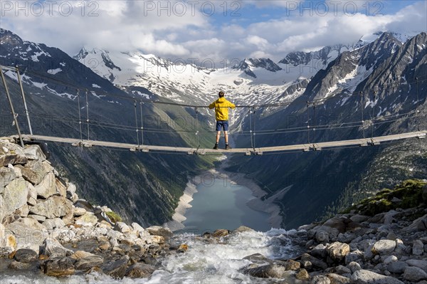 Mountaineers on a suspension bridge over a mountain stream Alelebach, picturesque mountain