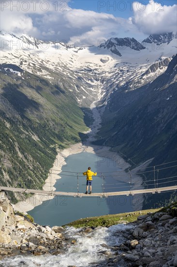 Mountaineers on a suspension bridge over a mountain stream Alelebach, picturesque mountain