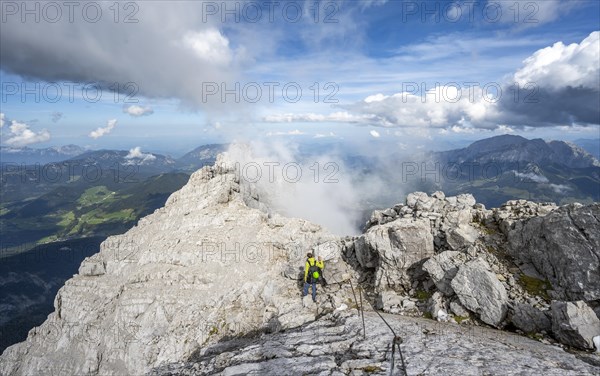 Climber on a via ferrata secured with steel rope, narrow rocky ridge, Watzmann crossing to Watzmann