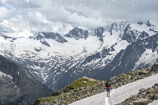 Mountaineer on hiking trail with snow, Berliner Hoehenweg, mountain landscape with glaciated peaks