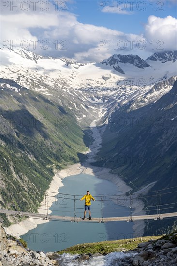 Mountaineers on a suspension bridge over a mountain stream Alelebach, picturesque mountain