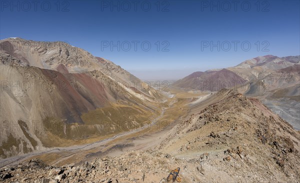 Mountain landscape of glacial moraines, mountains with red and yellow rocks, Traveller's Pass below
