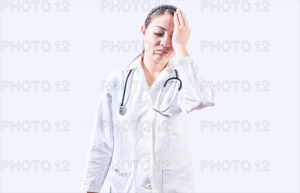 Exhausted female doctor with hand on forehead. Tired young female doctor with hand on forehead