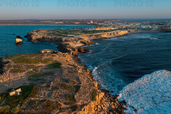 Sunset landscape of peninsula, bay and town of Peniche, Portugal. Summer sunset haze, little