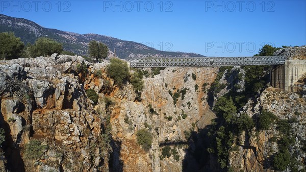 Metallic bridge over a deep gorge surrounded by a mountainous landscape, Aradena Gorge, Aradena,