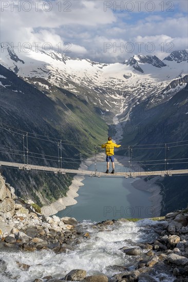 Mountaineers on a suspension bridge over a mountain stream Alelebach, picturesque mountain
