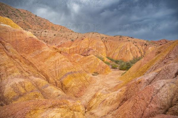 Eroded mountain landscape, sandstone cliffs, canyon with red and orange rock formations, Konorchek