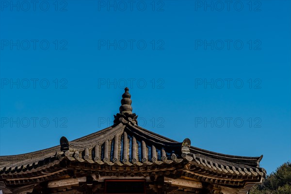Tiled rooftop of oriental gazebo against clear blue sky