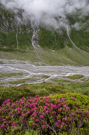 Mountain streams flow over steep mountain slopes into the Schlegeisgrund valley, cloudy rocky