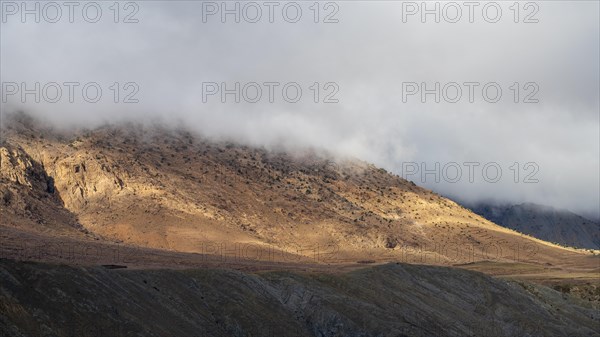 Low hanging clouds in the mountain landscape at the Tizi-n-Tichka pass road, High Atlas, Morocco,