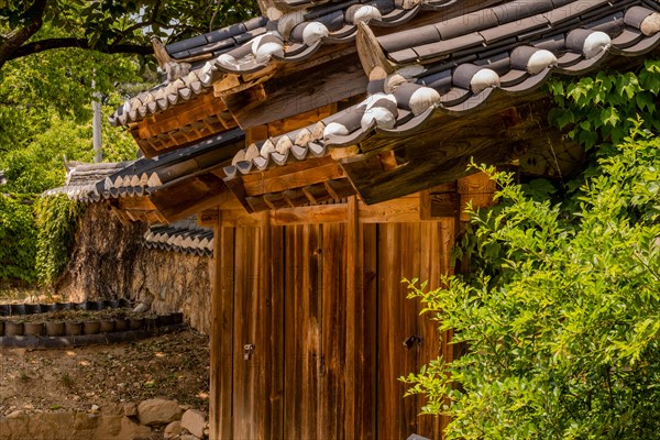 Ceramic tiles on roof of wooden gate located at public park displaying traditional Korean