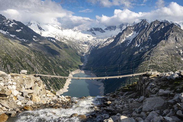 Suspension bridge over a mountain stream Alelebach, picturesque mountain landscape near the