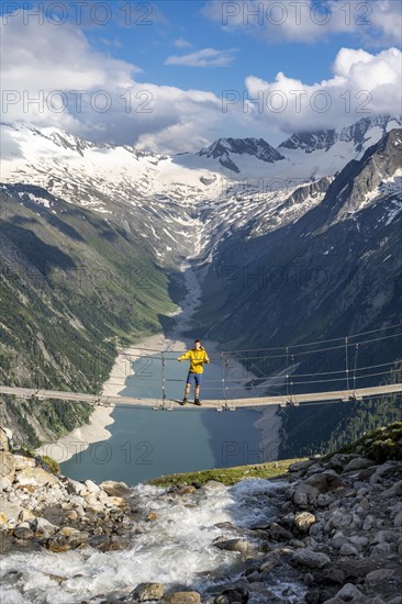 Mountaineers on a suspension bridge over a mountain stream Alelebach, picturesque mountain