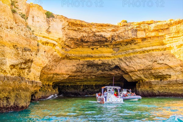 Albufeira, Portugal, May 28, 2022: Tourists in the boats sightseeing the caves on Algarve coast,