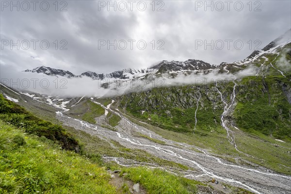 Cloudy valley of the Schlegeisgrund with mountain stream, glaciated mountain peaks Hoher Weiszint