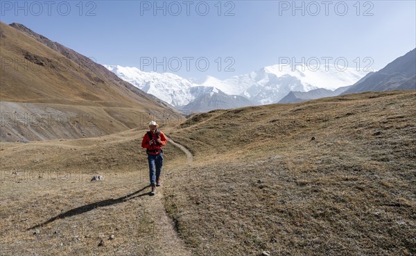 Mountaineers in the Achik Tash valley, in the background glaciated and snow-covered mountain peak
