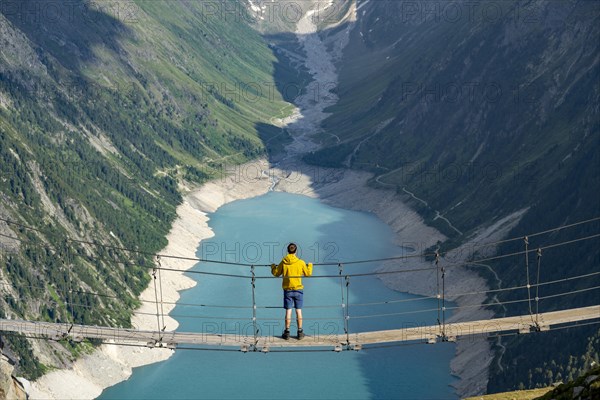 Mountaineers on a suspension bridge, picturesque mountain landscape near the Olpererhuette, view of