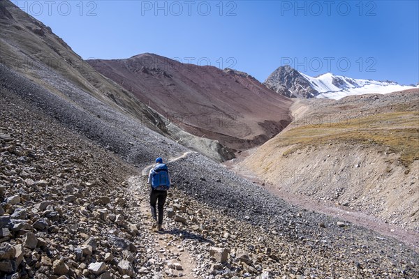 Barren high mountains, hiker on the hiking trail to the base camp of Lenin Peak, Osh Province,
