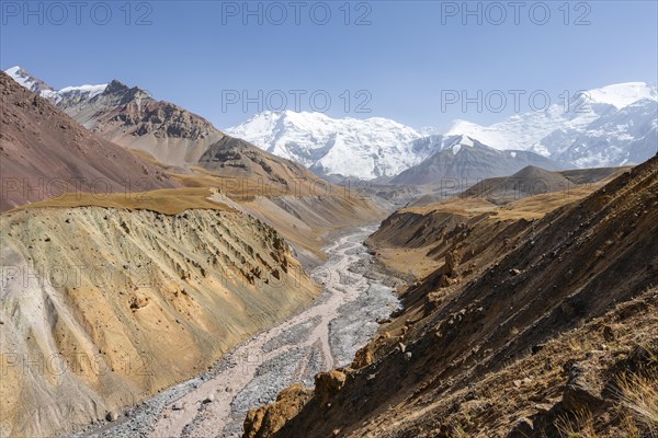 Achik Tash river, Achik Tash valley with rock formations, behind glaciated and snow-covered