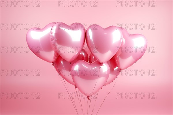 Bunch of glossy pink heart-shaped balloons against a soft pink background, perfect for Valentine's