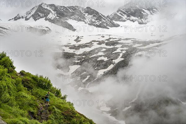 Mountaineers on a hiking trail, in the background glaciated peak Dosso Largo and glacier