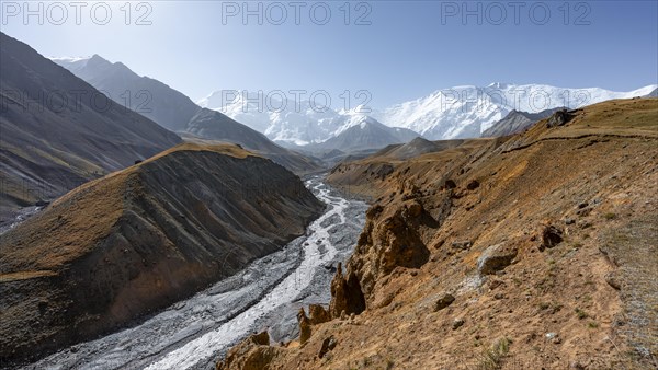 Achik Tash river, Achik Tash valley with rock formations, behind glaciated and snow-covered