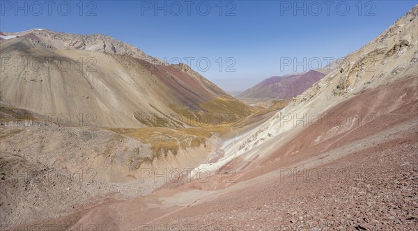Mountain landscape of glacial moraines, mountains with red and yellow rocks, Traveller's Pass below